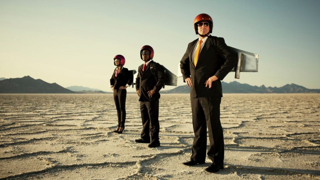 三名男子代表一个小型企业团队，背上挂着临时火箭。
